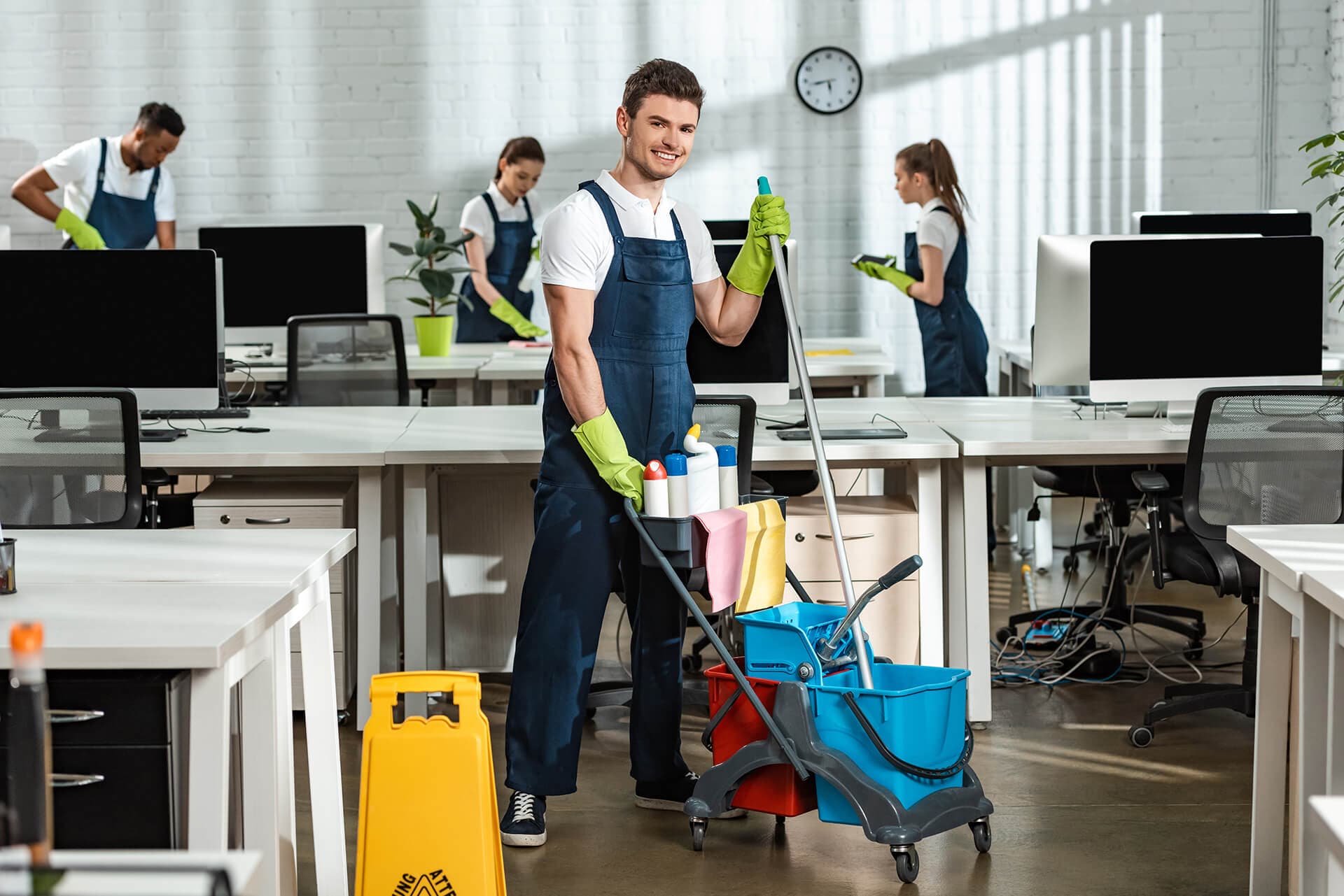Cleaner pushing supply cart in a hallway